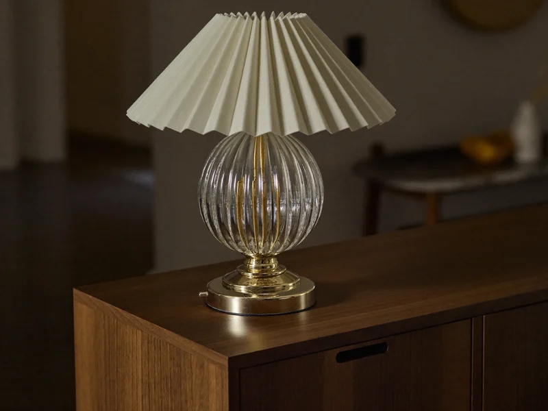 Illustrierte Tischleuchte mit geriffeltem Glas und Messingfuss auf Nussbaum-Sideboard
